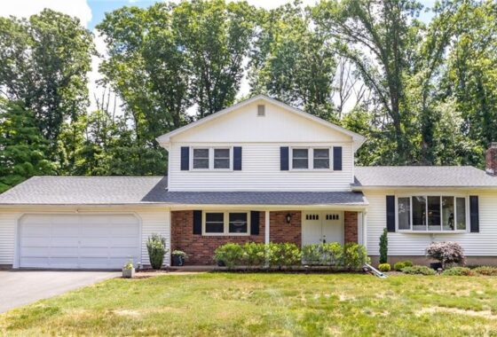 White suburban house with a large yard.