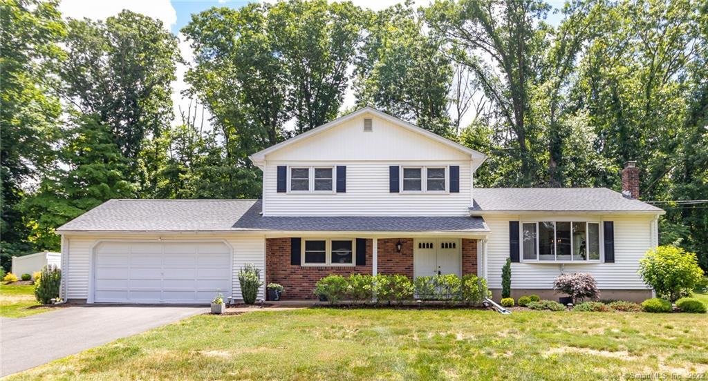 White suburban house with a large yard.