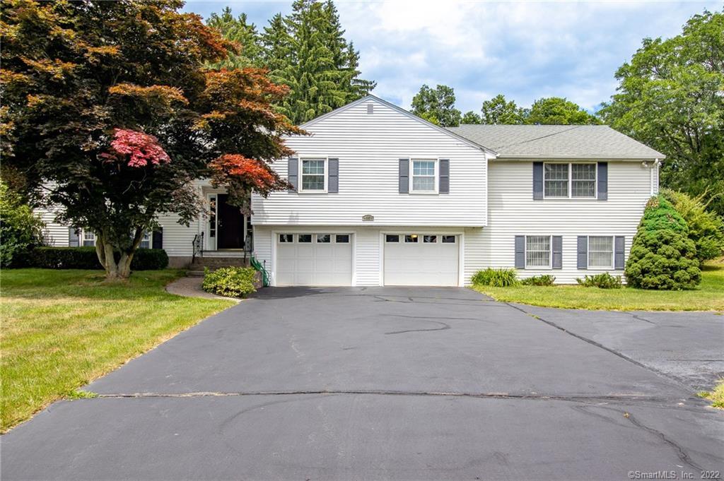 White two-story house with a double garage and paved driveway.