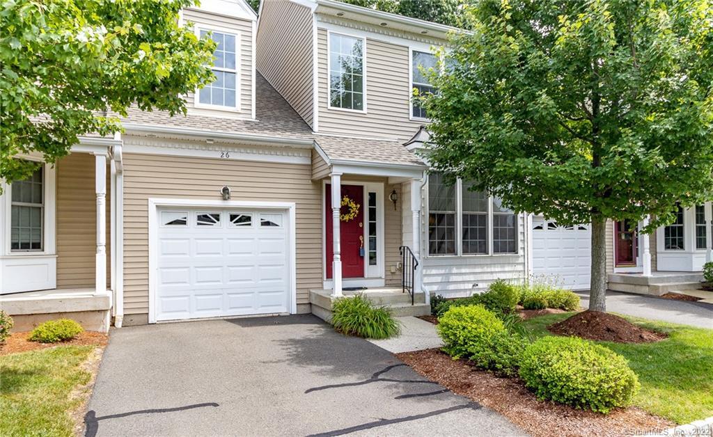 A charming suburban house with beige siding and a red front door.