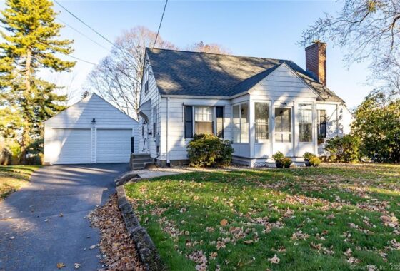 Charming suburban house with a well-kept lawn and detached garage.